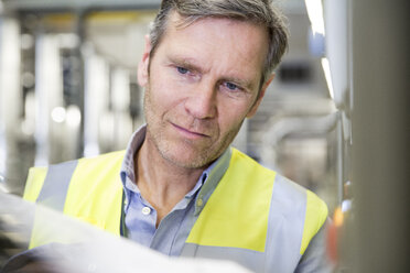 Man wearing reflective vest in industrial plant - FKF001745