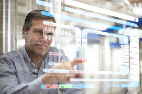 Mann benutzt transparentes Touchscreen-Gerät, lizenzfreies Stockfoto
