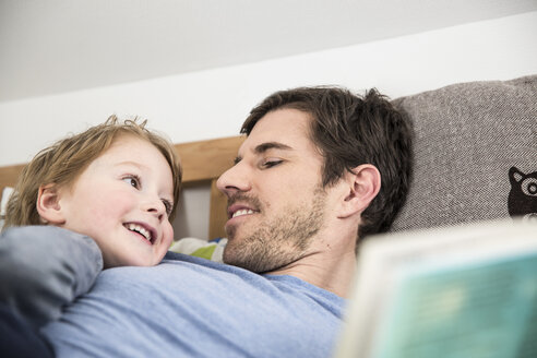 Vater und Sohn schauen sich lächelnd an - FMKF002542