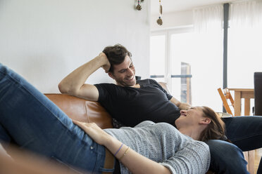 Affectionate couple relaxing at home on sofa - FMKF002579