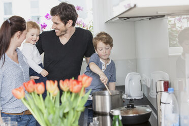 Family with two kids preparing food in kitchen - FMKF002590