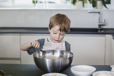 Kleiner Junge hilft bei der Zubereitung von Essen in der Küche - FMKF002595