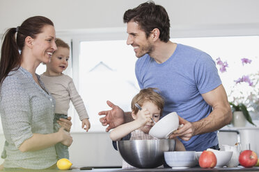 Familie mit zwei Kindern bei der Essenszubereitung in der Küche - FMKF002597