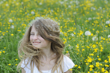 Portrait of smiling girl with dandelion seed on her hair - CRF002747