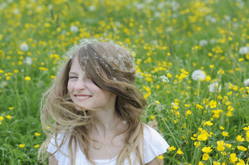 Porträt eines lächelnden Mädchens mit Löwenzahnsamen im Haar - CRF002747