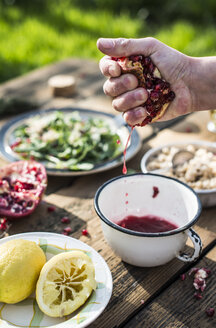 Zubereitung von grünem Salat mit Granatapfel, Manna Croup und Frühlingszwiebeln, Granatapfel auspressen, Dressing - DEGF000765