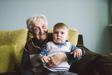 Old woman and her great-grandson sitting on the couch - RAEF000958