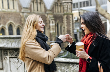 UK, London, Zwei Freunde erkunden die Stadt, trinken Kaffee vor der Southwark Cathedral - MGOF001576