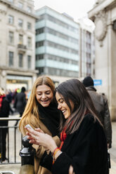 UK, London, Zwei Freunde erkunden die Stadt, mit Smartphone - MGOF001592