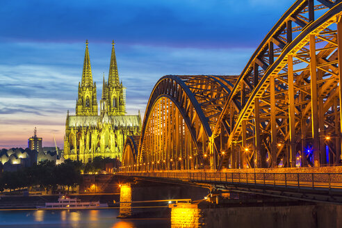 Deutschland, Köln, Blick auf den beleuchteten Kölner Dom mit der Hohenzollernbrücke im Vordergund - TAMF000416