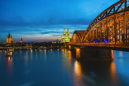 Deutschland, Köln, Blick auf den beleuchteten Kölner Dom mit der Hohenzollernbrücke im Vordergund - TAMF000418