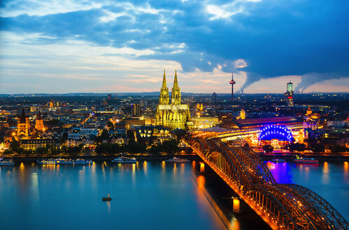 Deutschland, Köln, Blick auf beleuchtetes Stadtbild mit Kölner Dom und Hohenzollernbrücke - TAMF000421