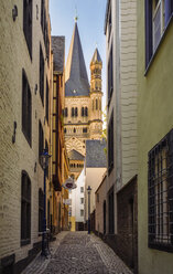 Deutschland, Köln, Blick durch eine Gasse mit Groß Sankt Martin im Hintergrund - TAMF000427
