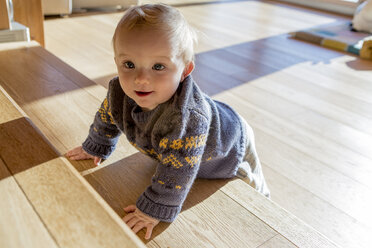 Porträt eines kleinen Jungen, der sich zu Hause auf eine Holztreppe stützt - ZOCF000013