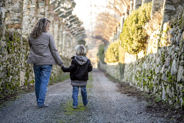 Rückenansicht einer Mutter, die Hand in Hand mit ihrem kleinen Sohn geht - ZOCF000016