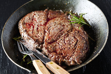 Rib eye steak with rosmary in frying pan - CSF027349