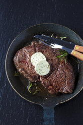 Rib-Eye-Steak mit Rosmarin und Kräuterbutter in der Bratpfanne - CSF027350