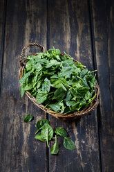 Fresh leaf spinach in basket on dark wood - CSF027365