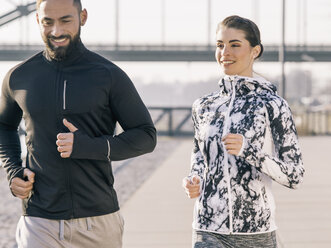 Germany, Cologne, Young couple worming up for workout - MADF000867