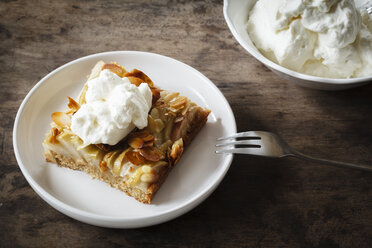 Piece of whole meal apple pie with sliced almonds and whipped cream - EVGF002861