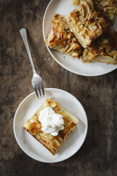Piece of whole meal apple pie with sliced almonds and whipped cream - EVGF002865