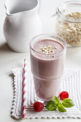 Glass of raspberry milkshake with oatflakes and basil - EVGF002877