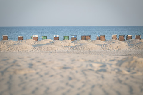Deutschland, Warnemünde, Strand mit Kapuzenstrandkorb, lizenzfreies Stockfoto