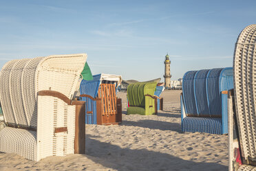 Deutschland, Mecklenburg-Vorpommern, Warnemünde, Strand mit vermummten Strandkörben und Leuchtturm im Hintergrund - ASCF000536