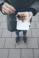 Belgium, Antwerp, young man eating Belgian waffles on the street - RTBF000025