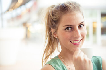 Portrait of smiling blond woman at outdoor cafe - ZOCF000024