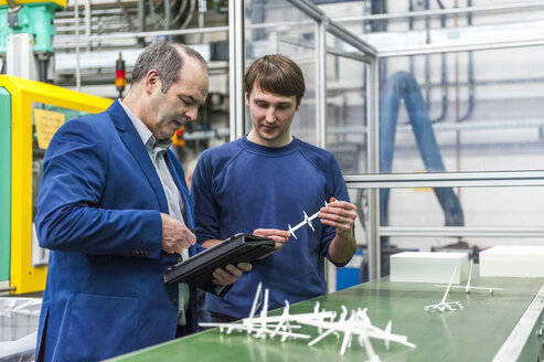 Manager und Arbeiter bei der Qualitätsbewertung in einer Kunststofffabrik - DIGF000106