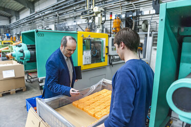 Manager und Arbeiter bei der Prüfung von Kunststoffprodukten in einer Fabrik - DIGF000116
