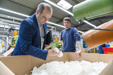 Manager und Arbeiter bei der Prüfung von Produkten in einer Kunststofffabrik - DIGF000120