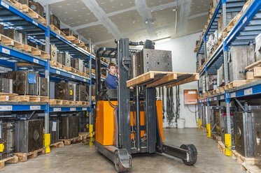 Warehouse worker driving forklift in storage for machine blocks - DIGF000131