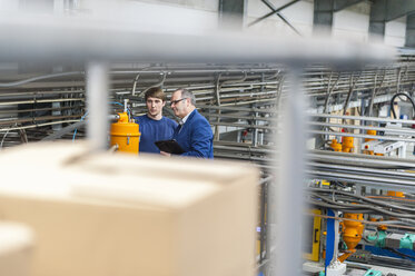 Manager und Arbeiter bei einer Arbeitsbesprechung in einer Kunststofffabrik - DIGF000147