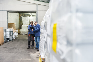 Manager und Arbeiter im Lager einer Kunststofffabrik bei der Produktkontrolle - DIGF000154