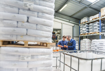 Manager und Arbeiter im Lager einer Kunststofffabrik bei der Produktkontrolle - DIGF000156