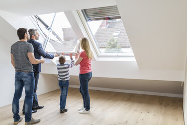 Familie und Immobilienmakler beim Öffnen des Dachfensters - SHKF000526