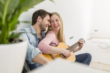 Happy couple playing guitar and singing - SHKF000557