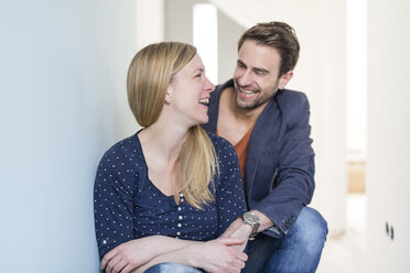 Lachendes Paar, das sich in seiner neuen Eigentumswohnung an den Händen hält - SHKF000572
