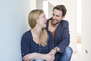 Laughing couple holding hands in their new freehold apartment - SHKF000572