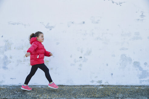 Little girl walking in front of a wall - ERLF000153