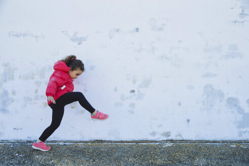 Little girl marching in front of a wall - ERLF000155