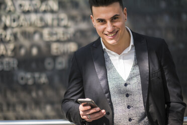 Porträt eines lächelnden Geschäftsmannes mit Smartphone - SIPF000280