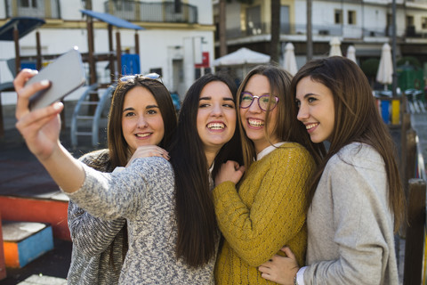 Vier junge Frauen machen ein Selfie mit Smartphone, lizenzfreies Stockfoto