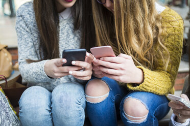 Junge Frauen nutzen ihre Smartphones - KIJF000262
