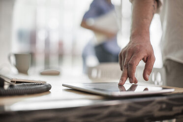 Person using tablet on table - ZEF008617