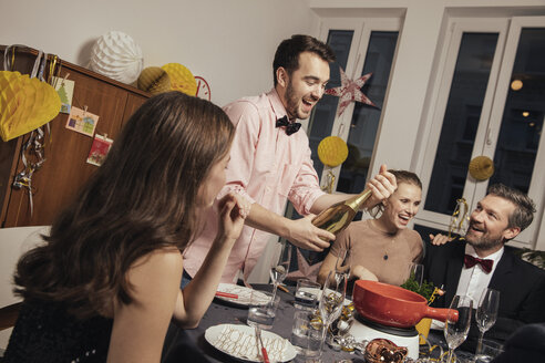 Fröhliche Gruppe von Freunden, die am Silvesterabend Champagner öffnen - MFF002924