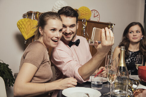 Freunde machen am Silvesterabend Selfies mit dem Smartphone - MFF002934