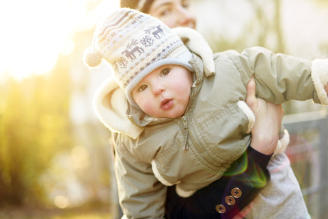 Porträt eines kleinen Mädchens, das vom Arm seiner Mutter gehalten wird, lizenzfreies Stockfoto